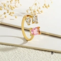 Close-up of gold adjustable ring with pear-cut white and emerald-cut pink crystals - Adjustable Open / Pink Main Stone Style(RG0629-B)