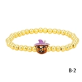 Detailed macro view of a Halloween gold beaded bracelet with a pumpkin witch hat charm - Orange Witch Hat Pumpkin (BR1914-B-2)