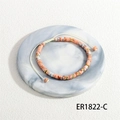 Macro detail of Bohemian woven bracelet with orange marble beads and gold spacers on marble tray - Orange White Marble Pattern Style (BR1822-C)