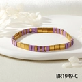 Détail du bracelet en perles Tila avec glaçure violette et accents dorés sur un plateau - Violet/Or (BR1949-C)