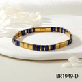 Vue détaillée du bracelet en perles Tila bleu marine et or sur un plateau en pierre - Bleu Foncé/Or (BR1949-D)