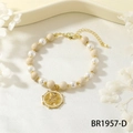 Detailed macro shot of an elastic pearl bracelet with snake charm and gold accents - White Wood Fossil