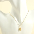 Macro detail of 18K gold plated seashell pendant necklace on a jewelry neck display - Gold