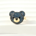 Macro shot of bear ring featuring blue and black micro-pave zircons on gold metal - Adjustable Open / Gold-Deep Blue Zirconia