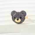 Makro-Detail des 3D-Bärenrings mit lila Zirkon-Pflastersteinen und schwarzem Herzakzent - Einstellbar Offen / Gold - Violetter Zirkonia