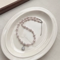 Pink pearl necklace with a square cubic zirconia pendant on a white ceramic plate - Manta Rose Square Rhinestone Pearl Necklace