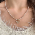 Elegant gold rocking horse pendant on a white pearl necklace worn on a white sweater - Gold Full Diamond Horse Pearl Style