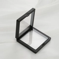 Schwarze PE-Folie Schwebende Schmuckschatulle mit Drucköffnung auf weißem Seidenstoff - 9x9cm / Schwarz