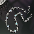 Silver thorn chain necklace with moonstone pendants on a sleek black reflective surface - Moonstone Color Thorns Necklace
