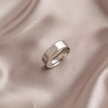 Minimalistischer polierter Edelstahlring in Silber auf elegantem Champagner-Seidenstoff - US 6 / 6mm Glatter Stil