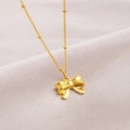Élégant collier pendentif nœud plaqué or 18K avec chaîne perlée sur fond en soie grise - Collier Perles Nœud Papillon Or