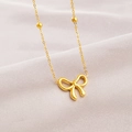 Élégant collier doré avec pendentif nœud sur fond de tissu en soie rose doux - Collier Petit Nœud Papillon Or