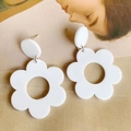 Macro view of white matte acrylic flower drop earrings with hollow petal design - White