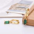 Macro shot of 925 sterling silver hoop earrings with rectangular green zircon pendants - Gold Plated Green Zirconia