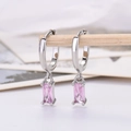 Detail of elegant silver drop earrings with rectangular pink zircon crystals on a wooden stand - Platinum Plated Pink Zirconia