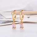 Detail of gold hoop earrings featuring rectangular pink zircon pendant on a wooden stand - Gold Plated Pink Zirconia