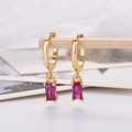 Macro detail of gold earrings with rectangular rose red zircon stones on wood stand - Gold Plated Rose Red Zirconia