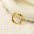 Detailed view of polished 18k gold geometric square ring on a white ceramic base - US 6 / Gold