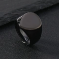 Macro detail of men's matte black stainless steel signet ring on a dark stone surface - US 6 / Black