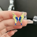 Detailed macro shot of a blue and yellow gradient butterfly ring on hand with ice decor - Premium Butterfly Style 3 / Yellow & Blue Woven (3#-C)