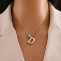 Dettaglio della collana in oro 18k con ciondolo lettera D bombata e occhio portafortuna - Lettera D Oro