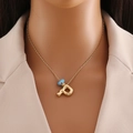 Détail du collier en or 18 carats avec initiale P et perle bleue œil protecteur - Lettre P Or