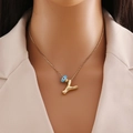 Collier en or 18 carats avec un pendentif lettre Y et une breloque œil bleu sur un mannequin - Lettre Y Or