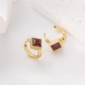 Detailed macro view of 18k gold-plated square red gemstone hoop earrings on a stone base - Gold / Red Rhinestone