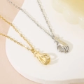 Gold and silver hand gesture pendant necklaces displayed on a decorative white plate - Realistic Gesture / Gold