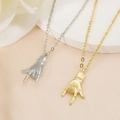 Chic gold and silver rock sign hand gesture pendant necklaces on white silk backdrop - Rock Gesture / Gold