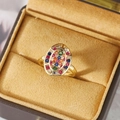 Detail of bohemian gold ring featuring oval multi-color zircon inlay in jewelry box - US 6 / Gold