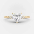 Macro shot of gold heart ring with round side stones and polished metal finish - US 6 / Gold