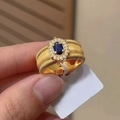 Vintage gold wide ring with blue oval gemstone and sparkling diamond halo on finger - US 6 / Gold Blue