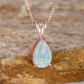 Halskette mit Opal-Anhänger in Birnenform aus Roségold auf natürlichem Stein-Hintergrund - Box-Kettenstil / Roségold