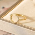 Close-up of golden hollow ring featuring micro-paved zircons on a satin background - US 6 / Gold