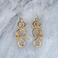Detailed macro shot of a golden snake ear hook showing realistic scales and texture - Gold