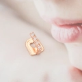 Macro-opname van roségouden tandgrill met hartvormig gat en vijf verticale zirkonia's - Roségoud