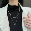 Elegante dubbele zilveren ketting met sprankelende cilinder hanger op model gedragen - Zilveren Glinsterende Taille Hanger Ketting