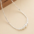 Elegante zilveren kraal en parelmoer ketting op een getextureerde lederen achtergrond - Zilveren Stijl