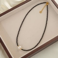 Vintage zwarte kristallen ketting met zoetwaterparel en gouden hartvormig detail - Zwarte Kristal Zoetwaterparel Ketting