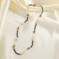 Vintage ketting met blauwe stenen, parels en kristallen op zijden achtergrond - Blauwe Natuursteen Parelketting