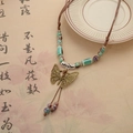 Etnische retro ketting met bronzen vlinder hanger en groene keramische kralen - Grote Keramische Vlinder Ketting Met Trekkoord