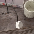 Minimalistische silberne Kamm-Halskette mit verstellbarer schwarzer Kordel auf Holztisch - Abgerundeter Kamm-Stil