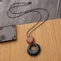 Long collier avec pendentif anneau noir et perle d'ambre sur un tapis de bambou - Glaçure Noire (Ambre)