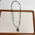 Minimalist silver water drop necklace with black gemstone inlay on brown wood tray - Black Agate Teardrop Necklace