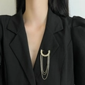 Eleganter vergoldeter Quasten-Anstecker mit Zirkonia an einem schwarzen Revers - Zirkon Quaste Stil