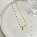 Minimalistische goudkleurige ketting met bamboe hanger en hartje op wit keramisch dienblad - Bamboeknoop Ketting