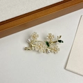 Elegante spilla a ramo di fiori dorati con petali bianchi, foglie smaltate e perle - Stile Fiore con Perla e Strass
