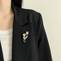 Élégante broche tulipe plaquée or avec zircons et perle blanche sur un blazer noir - Style Tulipe Perle