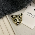 Goldene Leoparden-Brosche mit schwarzer Emaille und weißen Strasssteinen auf Textil - Gold